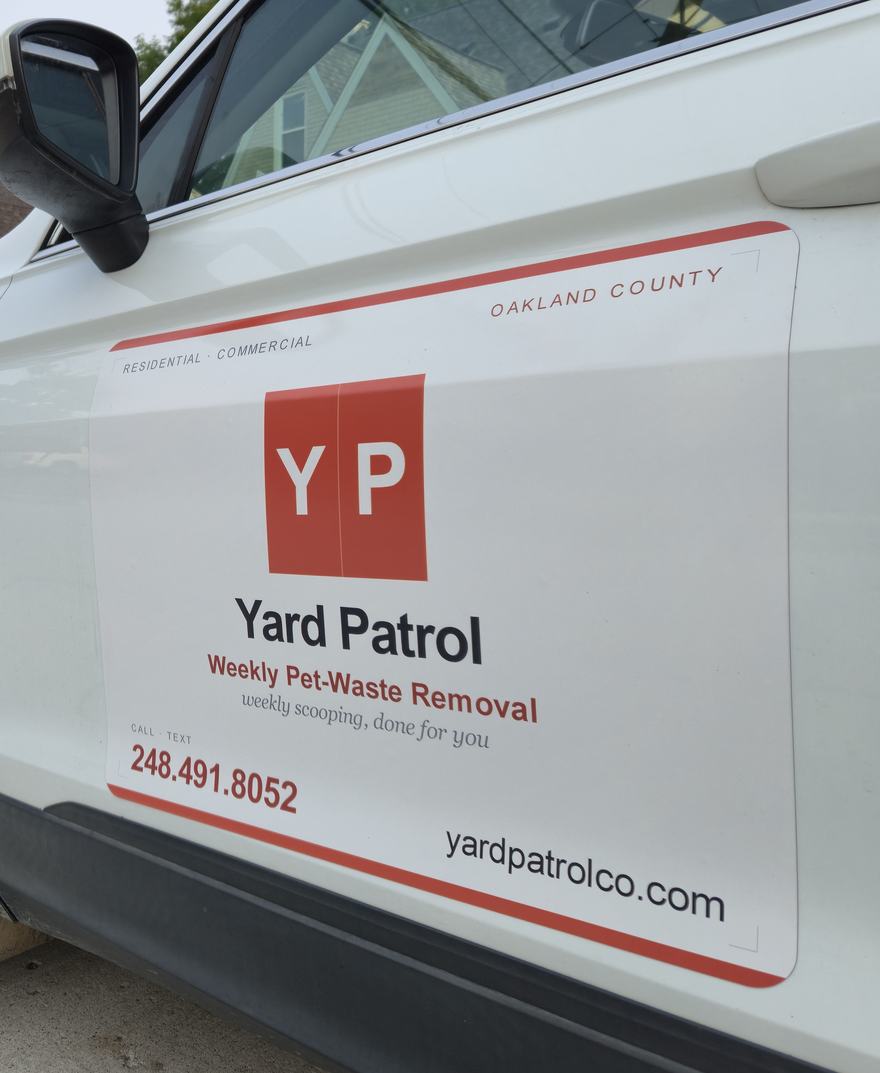 The Yard Patrol vehicle parked curbside in Oakland County — door magnet with the YP mark, (248) 491-8052, and yardpatrolco.com.