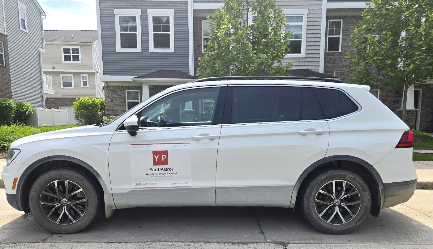 The Yard Patrol work vehicle with its door magnet on the weekly pet-waste pickup route in Oakland County.